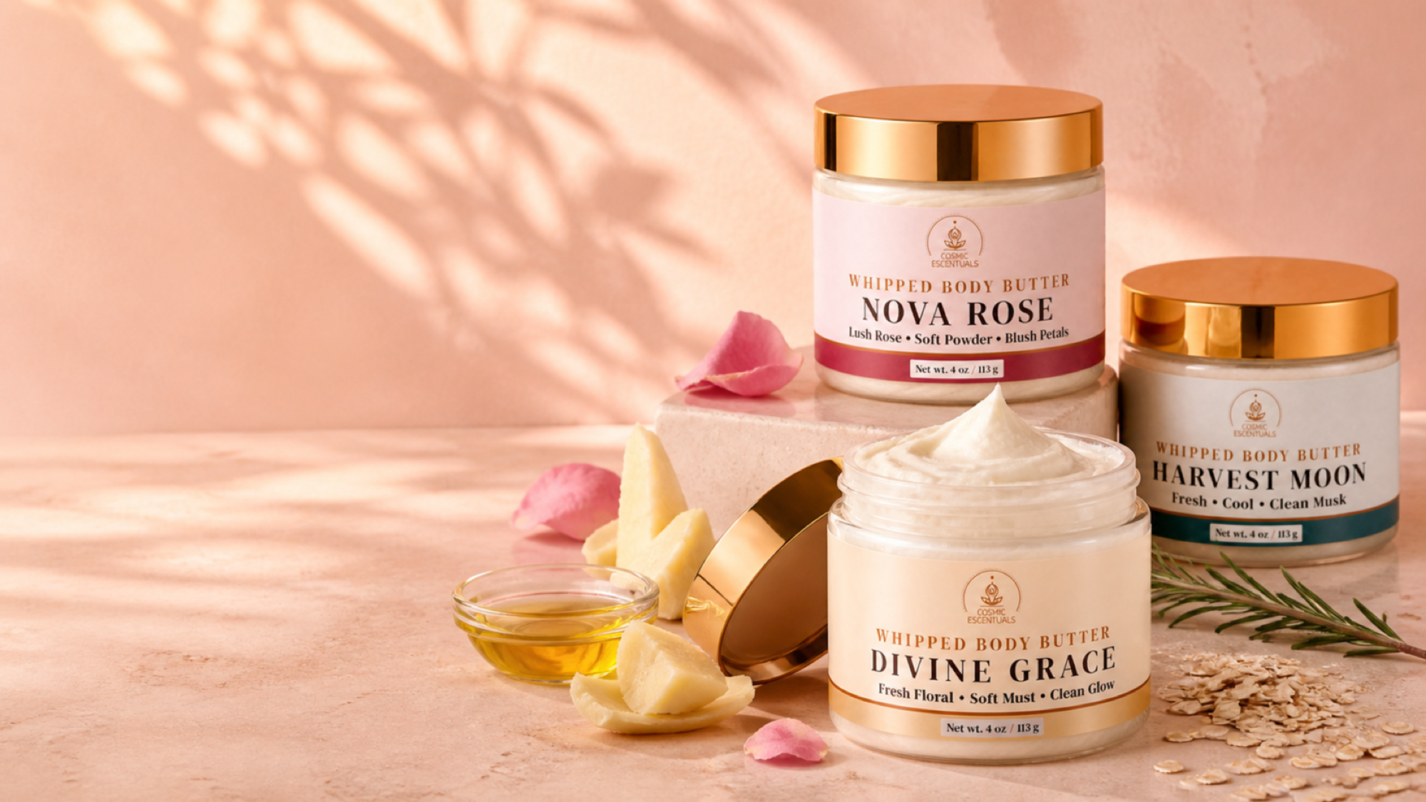 Three whipped body butter jars arranged on a warm peach surface with rose petals, a small dish of honey, and botanical props. The center jar is open, showing white whipped product, while the other two jars are closed with gold lids.