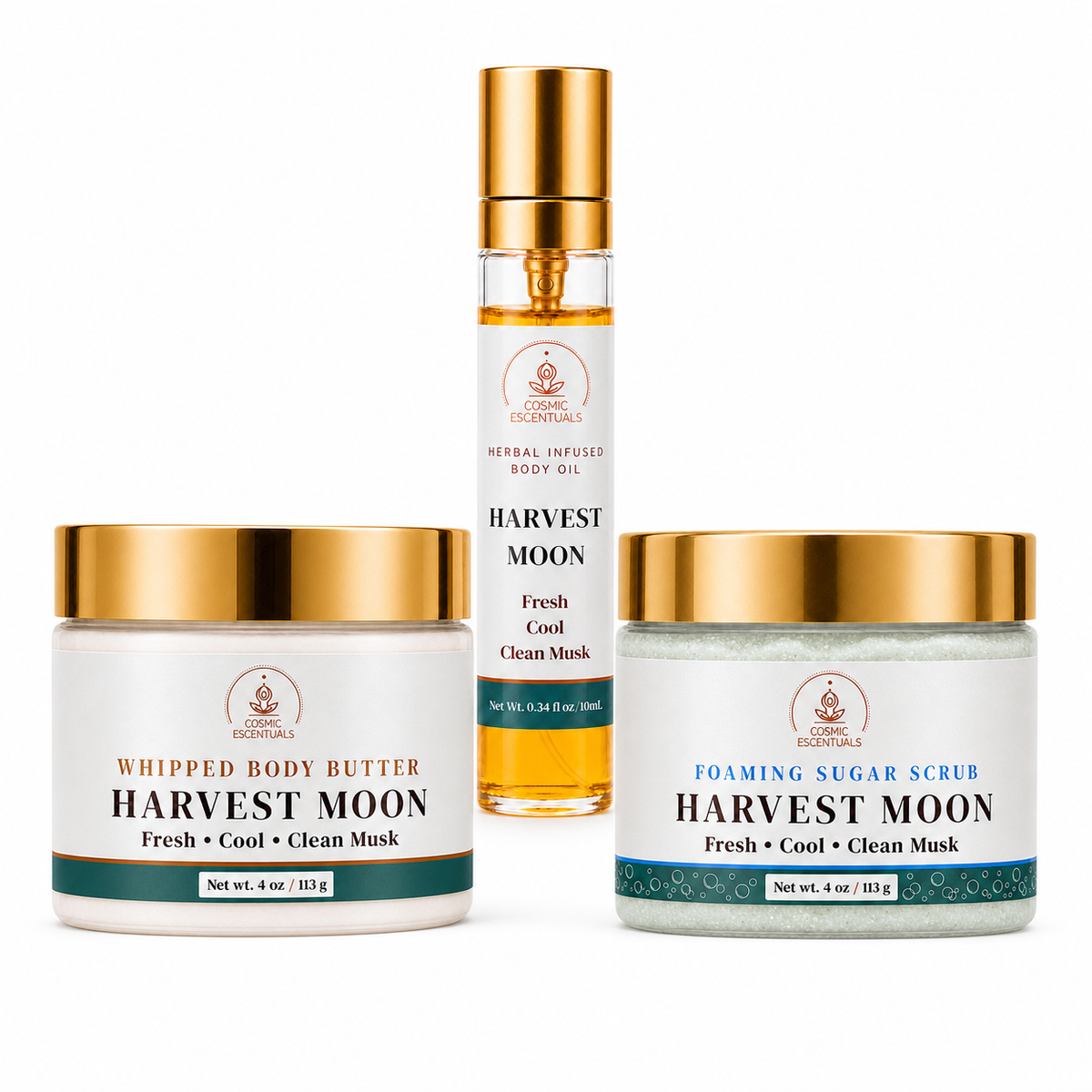 Three skincare products from Cosmic Escentuals on a white background: a jar of Whipped Body Butter, a spray bottle of Harvest Moon Fresh Cool Clean Musk body oil, and a jar of Foaming Sugar Scrub.