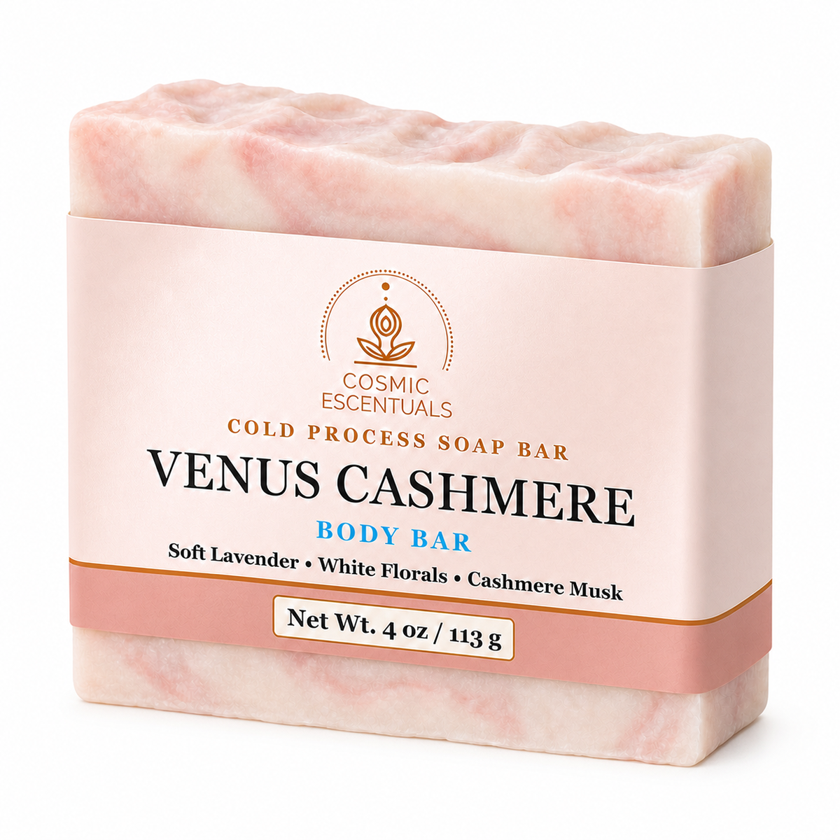 A bar of COSMIC ESSENTUALS Venus Cashmere body soap, wrapped in a light pink paper sleeve with gold and blue text, set against a plain white background.