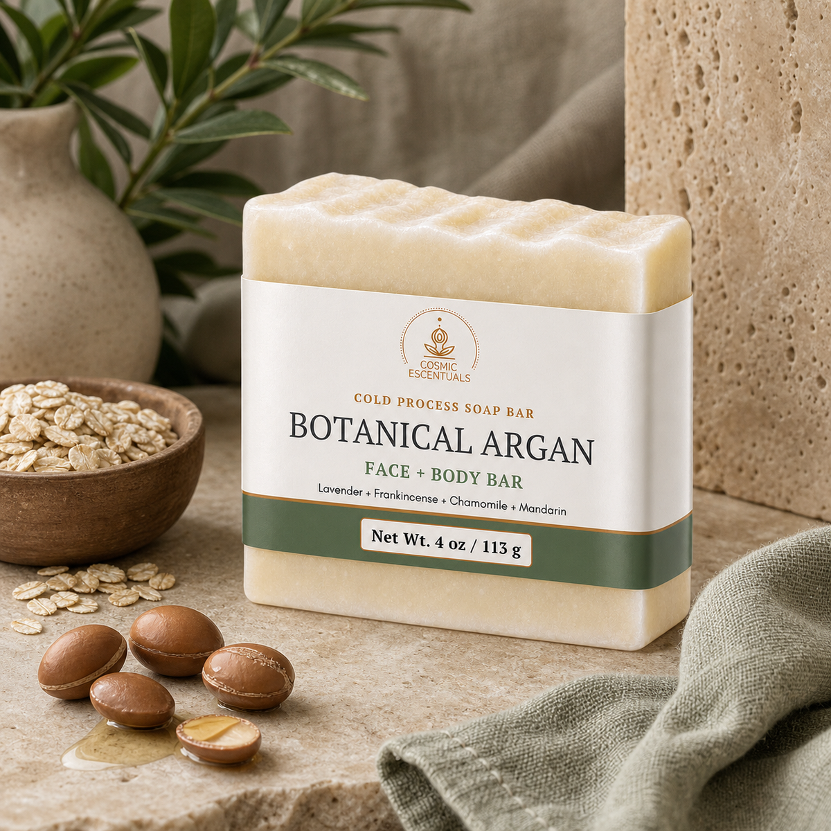 Botanical Argan Body Bar standing on a stone counter, styled with a bowl of oats, whole and cracked argan nuts, an olive branch and a sage green linen cloth.