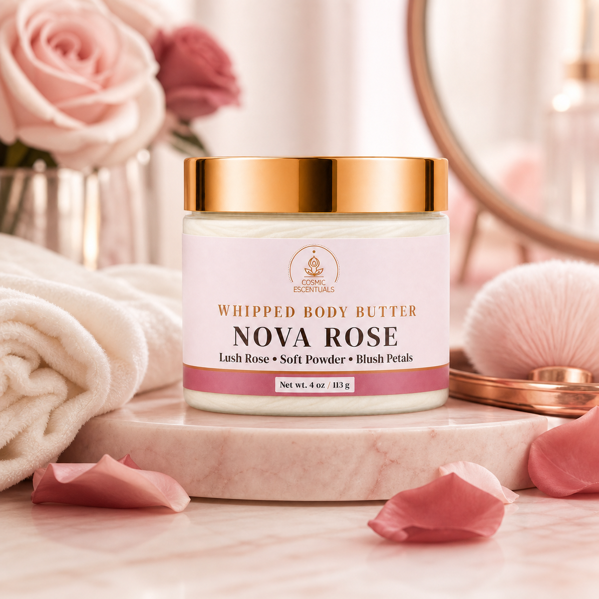 A jar of Cosmic Escentuals Whipped Body Butter in the Nova Rose scent, styled on a marble slab with pink rose petals, a rolled towel, and soft pink roses in the background.