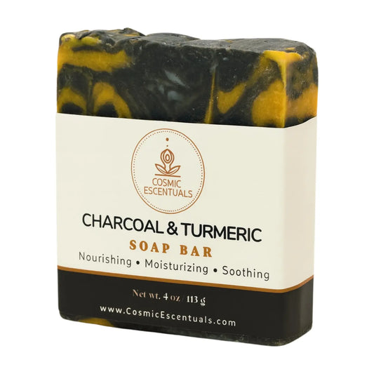 Charcoal and turmeric soap bar with Cosmic Escentuals branding on a white background