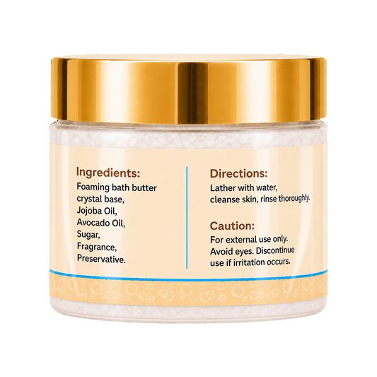 Foaming bath butter in a clear jar with a shiny gold lid and a cream-colored label containing product instructions and ingredients.
