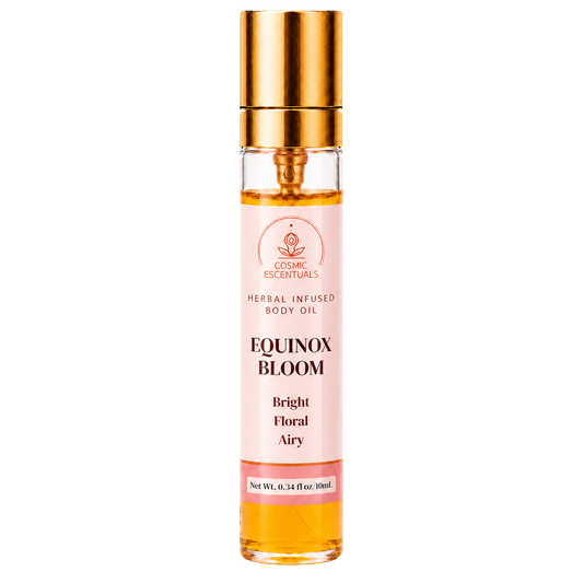 Cosmic Essentials Equinox Bloom Herbal Infused Body Oil in a clear glass roller bottle with a gold cap and a light pink label, shown on a white background.