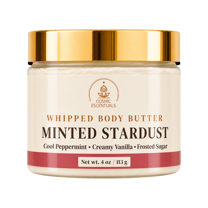 Cosmic Essentials Whipped Body Butter in Minted Stardust scent, in a 4 oz jar with a cream-colored label, a metallic gold lid, and a dusty rose accent band at the bottom.