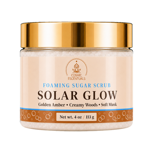 Cosmic Escentuals Solar Glow Foaming Sugar Scrub, 4oz jar with a shiny gold lid and a beige label, on a plain white background.