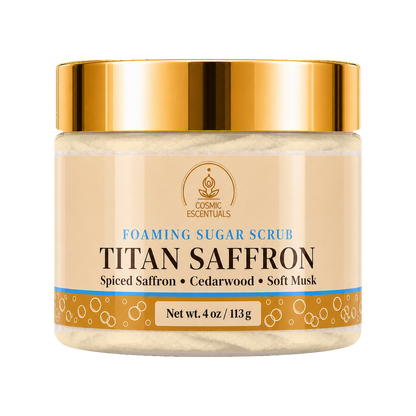 Cosmic Essentials Titan Saffron Foaming Sugar Scrub in a clear jar with a metallic gold lid and beige label, shown on a plain white background.