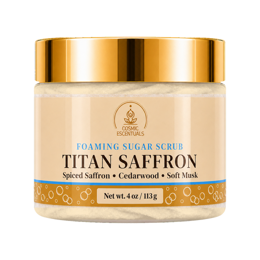 Cosmic Essentials Titan Saffron Foaming Sugar Scrub in a clear jar with a metallic gold lid and beige label, shown on a plain white background.