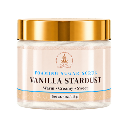 A jar of Cosmic Essentials Vanilla Stardust Foaming Sugar Scrub with a shiny gold lid and a cream-colored label, shown on a plain white background.