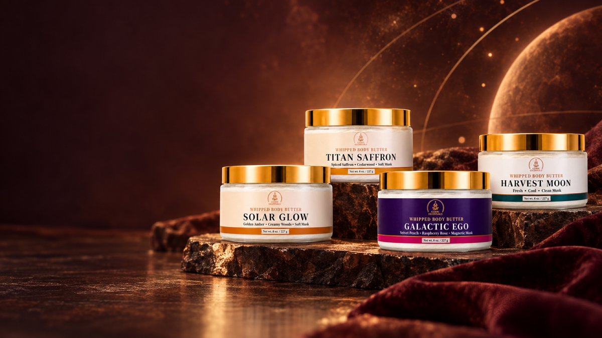 Solar Glow, Titan Saffron, Galactic Ego, and Harvest Moon whipped body butters arranged in a warm autumn cosmic setting.